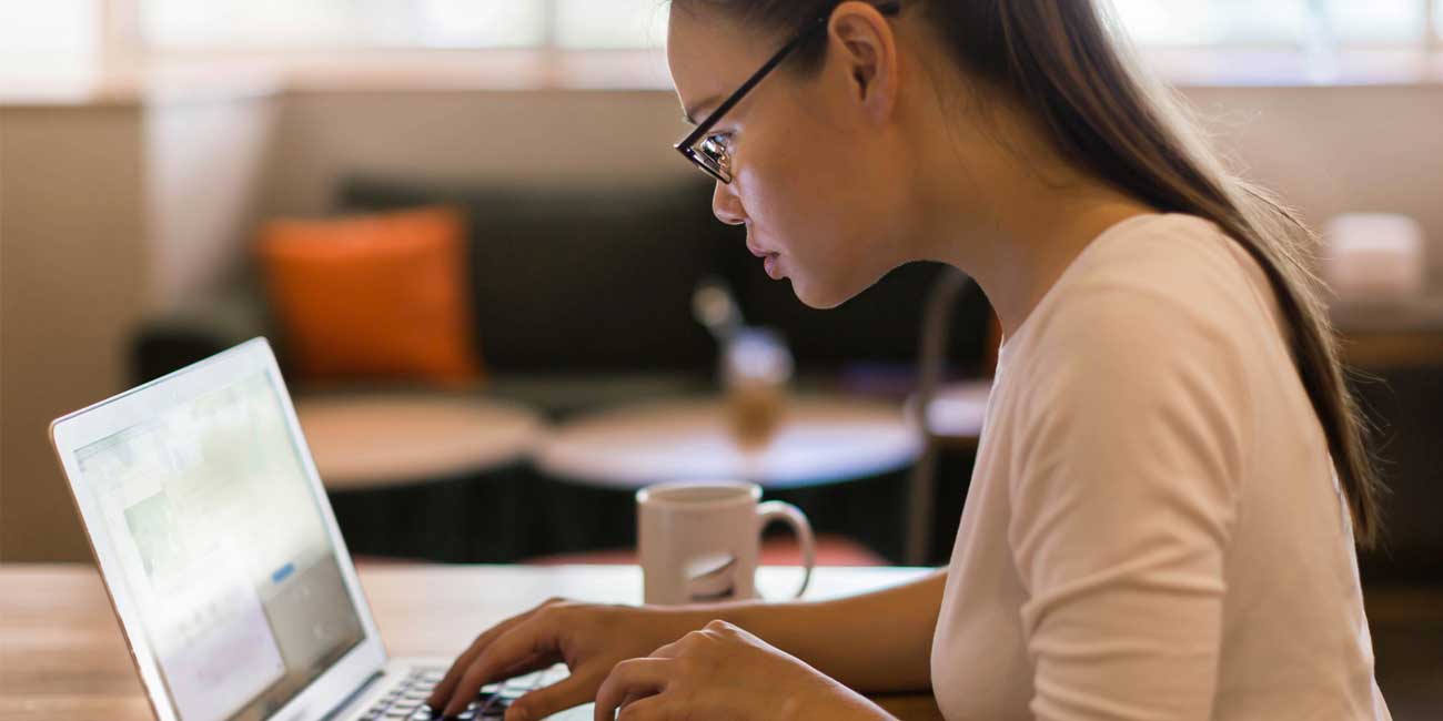 woman sitting in front of computer completing a web form